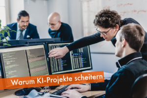 Personen im Büro an einem Computer als Symbol für scheiternde KI-Projekte